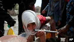A girl drinks water from a well that is allegedly contaminated with cholera bacteria, on the outskirts of Sanaa, Yemen, July 12, 2017. The U.N. health agency said Tuesday that plans to ship cholera vaccine to Yemen are likely to be shelved over security, access and logistical challenges in the war-torn country. Yemen's suspected cholera caseload has surged past 313,000, causing over 1,700 deaths in the world's largest outbreak.