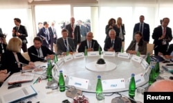 FILE - Representatives from Google, Microsoft, Facebook and Twitter meet with G-7 interior ministers to discuss efforts in combating extremism on the internet during a Group of Seven meeting in Italy, Oct. 20, 2017.