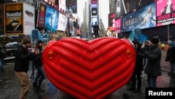 Drummers perform on "HeartBeat" by Stereotank, a Brooklyn-based design studio, which is the 2015 winning Times Square Valentine Heart produced by the Times Square Alliance, in New York City February 9, 2015. The interactive sculpture consisting of a massi