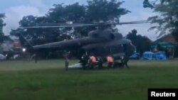 Madaktari wa huduma ya kwanza wakiwa wamembeba mtoto kumuingiza katika helikopta ili kumpeleka huko Chiang Rai, Thailand, July 8, 2018