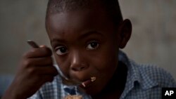 រូបឯកសារ៖ សិស្សសាលាម្នាក់ញ៉ាំអាហារនៅសាលាមួយ ដែលត្រូវបានយកធ្វើជាកន្លែងចែកចាយស្បៀងអាហាររបស់អង្គការស្បៀងអាហារពិភពលោក នៅប្រទេសហៃទី។ 