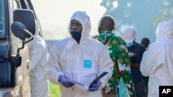 Forensics officers search near the scene of an explosion in the Komamboga suburb of the capital Kampala, Uganda, Oct. 24, 2021. 