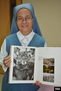 Sister Porferia Ocariza holds a book with a photo of herself during the Philippines "People Power Movement" that saw the ouster of dictator Ferdinand Marcos, Feb. 24, 2016. (S. Orendain/VOA)