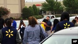 imagen provista por WREG-TV, muestra a empleados de Walmart en un círculo de oración afuera de la tienda, el martes 30 de julio de 2019, en Southaven, Mississippi, luego de un tiroteo. (Jerrita Patterson/WREG-TV via AP).