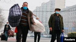 中国举行两会的周三，人们行走在北京市中心。（2021年3月10日）