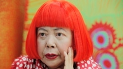 In this photo taken Wednesday, Aug. 1, 2012, Japanese avant-garde artist Yayoi Kusama, wearing a bright red wig and a Louis Vuitton polka dot scarf, speaks during an interview at her studio in Tokyo.