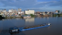 FILE - A cargo ship loaded with soil travels along the Tonle Sap river in Phnom Penh on Aug. 25, 2021.