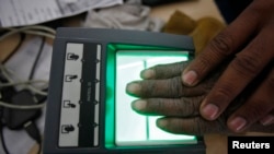 A villager goes through the process of a fingerprint scanner for the Unique Identification (UID) database system at an enrollment center at Merta district in the desert Indian state of Rajasthan, Feb. 22, 2013.