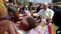 Pope Francis is cheered by locals as he visits a refugee camp, in Bangui, Central African Republic, Nov. 29, 2015.