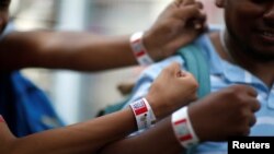 Migrantlar bilagiga maxsus bog’ich taqilmoqda. Bog’ich oqim hajmini nazorat qilishga xizmat qiladi. Meksika. 17-yanvar, 2019