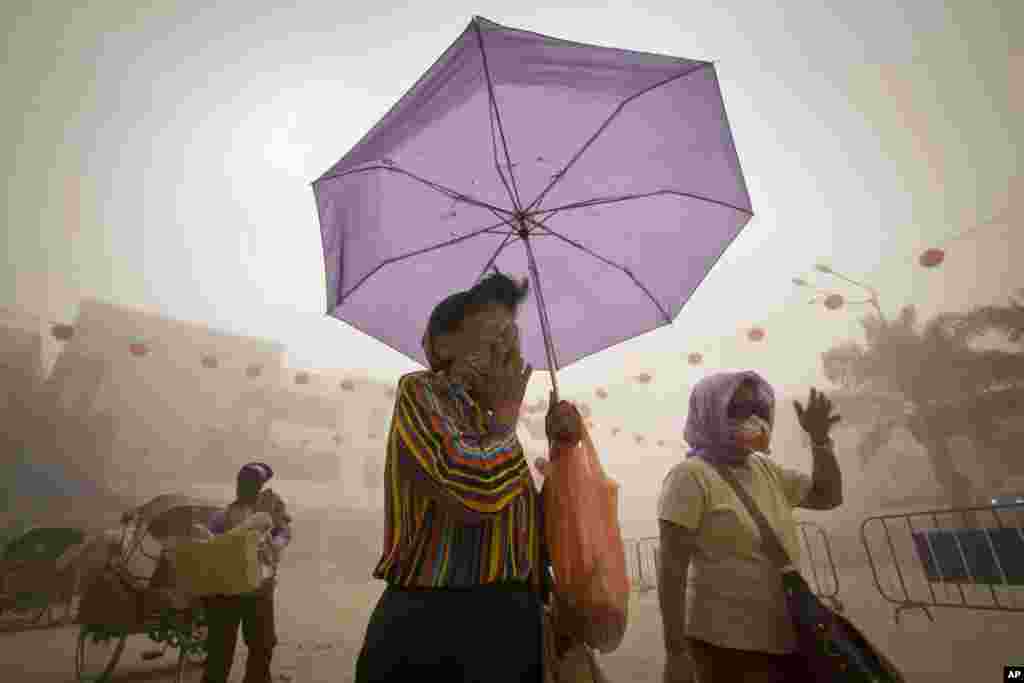 Villagers covering their faces from volcanic ash follwoing Mount Kelud's eruption in Solo, Indonesia, Feb. 14, 2014.