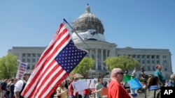 People gather outside the Missouri Capitol to protest stay-at-home orders put into place due to the COVID-19 outbreak, April 21, 2020, in Jefferson City, Missouri.
