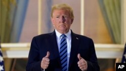 El presidente Donald Trump posa para los fotógrafos en la Casa Blanca a su regreso del Hospital Militar Walter Reed, donde fue asistido tras ser diagnosticado con el COVID-19.