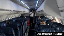 Flight attendants talk in a nearly empty cabin on a Delta Airlines flight operated by SkyWest Airlines as travel has cutback, amid concerns of the coronavirus disease (COVID-19), during a flight departing from Salt Lake City, Utah, U.S. April 11, 2020. RE