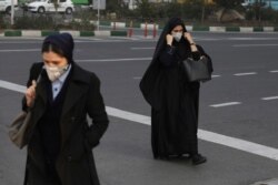 Pedestrians wearing face masks cross a square in western Tehran, Iran, Feb. 29, 2020.