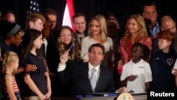 El gobernador de Florida, Ron DeSantis, firma cinco proyectos de ley estatales después de dar una conferencia de prensa en Cambridge Christian School en Tampa, Florida, el 17 de mayo de 2023. REUTERS/Octavio Jones