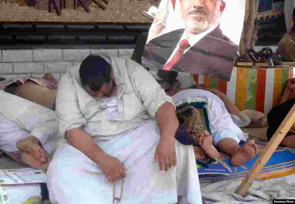 Exhaused Morsi supporter resting outside Muslim Brotherhood stronghold outside Cairo's Rabaa al-Adawiya mosque, July 11. Photo: VOA/Sharon Behn