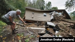 美國北卡羅來納州布恩，斯科特·理查森在勘察自己在熱帶風暴海倫(Helene) 襲擊後倒塌和毀壞的房屋時，指著自己家的地基曾經所在的位置。