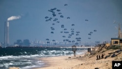 Un avión deja caer ayuda humanitaria sobre el norte de la Franja de Gaza. Foto captada desde el centro de Gaza, el lunes 25 de marzo de 2024. 