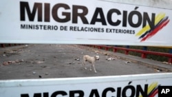 Lado venezolano del Puente Internacional Francisco de Paula Santander donde cuelgan carteles de migración en Ureña, Venezuela, el martes 26 de febrero de 2019, visto desde el otro lado del puente en Cúcuta, Colombia, mientras la frontera permanece cerrada