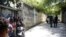 Periodistas se reúnen junto a los agentes de policía que hacen guardia cerca de la residencia privada del presidente de Haití, Jovenel Moise, después de que hombres armados lo mataran a tiros con rifles de asalto, Puerto Príncipe, el 7 de julio de 2021.