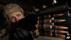 Un soldado ucraniano mantiene posta con armamento de combate en la línea fronteriza de Luhansk, cuando crece la tensión en la región. 