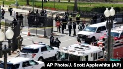 មន្ត្រី​ប៉ូលិស និង​ក្រុមមន្ត្រី​ពន្លត់​អគ្គីភ័យ​ឈរ​នៅ​ក្បែរ​រថយន្ដ​មួយ​គ្រឿង ដែល​បាន​បើក​បំបុក​របាំង​ការពារ​នៅ​វិមាន​សភា​សហរដ្ឋ​អាមេរិក​​ក្នុង​រដ្ឋធានី​វ៉ាស៊ីនតោន កាល​ពី​ថ្ងៃ​សុក្រ​ ទី២ ខែមេសា ឆ្នាំ២០២១។ 