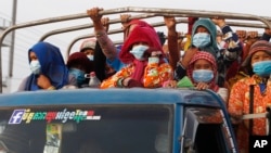 រូប​ឯកសារ៖ កម្មករ​រោងចក្រ​កាត់ដេរ​ជិះ​លើ​រថយន្ដ​ឈ្នួល​ធ្វើ​ដំណើរ​ទៅ​ធ្វើការ​នៅ​ជាយ​រាជធានី​ភ្នំពេញ ថ្ងៃទី៦ ខែឧសភា ឆ្នាំ២០២១។ (AP) 