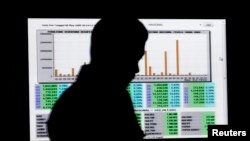 Seorang pria melewati layar perhitungan suara pemilu di kantor Komisi Pemilihan Umum (KPU) Pusat di Jakarta (foto: ilustrasi/dok). 