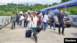 A group of Myanmar migrant workers cross the border between Thailand and Myanmar near the Thai port city of Ranong, July 3, 2017.