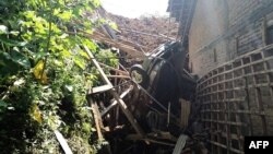 A handout photograph released April 1, 2017, by Indonesia's National Disaster Agency shows a trapped car and debris following a landslide that hit Banaran village, in Ponorogo district, East Java province, on April 1, 2017.