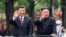 En la foto de archivo del 20 de junio de 2019, publicada por la Agencia de Noticias Xinhua de China, el presidente chino Xi Jinping, a la izquierda, y el líder norcoreano Kim Jong saludan desde una limusina mientras viajan por una calle en Pyongyang, Corea del Norte. 