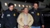 ARCHIVO - Agentes escoltan a Joaquín "El Chapo" Guzmán a su llegada en avión al aeropuerto MacArthur de Long Island, en Ronkonkoma, Nueva York, el 19 de enero de 2017. Guzmán escribió una carta al juez Brian Cogan, de la Corte del Distrito Este de Nueva York, por aislamiento.