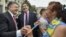 Ukrainian President Petro Poroshenko, left, and then-governor of Odessa region Mikheil Saakashvili, center, are greeted by a local resident near the regional state administration in Odessa, Ukraine, May 30, 2015.