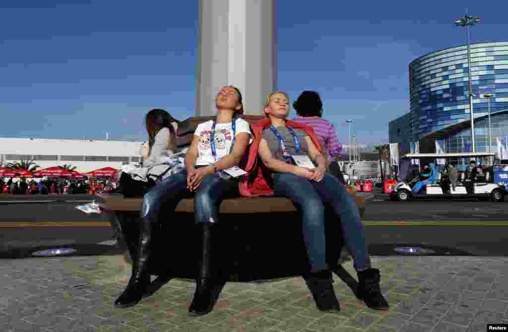 Women sun themselves in 60-degree weather at the Olympic Park, Sochi, Russia, Feb. 12, 2014. 