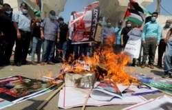 Palestinians burn pictures during a protest against the United Arab Emirates and Bahrain's deal with Israel to normalize relations, in Gaza City, Sept. 15, 2020.