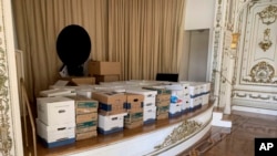 Esta imagen, incluida en la acusación contra el expresidente Donald Trump, develada el 9 de junio de 2023, muestra cajas de discos almacenadas en el escenario del White and Gold Ballroom en la propiedad de Trump en Mar-a-Lago en Palm Beach, Florida.
