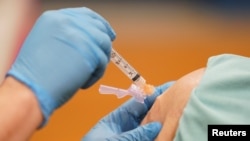 Arhiva, ilustracija - Medicinska radnica daje vakcinu građaninu u Martinsburgu, Zapadna Virdžinija, 11. marta 2021. (Rojters/Kevin Lamarque)