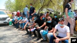 Jobless graduates gather in front of the Ministry of Oil to demand jobs in Baghdad, Iraq, Monday, July 20, 2020. In the Mideast, wave after wave of war, disease and economic collapse leaves this generation feeling hopeless. (AP Photo/Hadi Mizban)