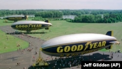 In this June 18, 1998 file photo, three Goodyear blimps, the then newly commissioned Stars and Stripes, foreground, the decommissioned Stars and Stripes, middle, and the Spirit of Akron are moored at the Goodyear blimp base in Suffield, Ohio. (AP Photo/Jeff Glidden)