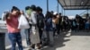 Los migrantes hacen fila mientras esperan un autobús a Chicago para transportarlos fuera de Eagle Pass, Texas, el 26 de septiembre de 2023, en el complejo Mission Border Hope.