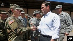 El gobernador de Arizona Doug Ducey, a la derecha, da la mano a los soldados de la Guardia Nacional de Arizona antes del despliegue en la frontera con México en la Reserva Militar de Papago Park el lunes 9 de abril de 2018, en Phoenix.