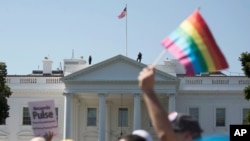 FILE - Equality March for Unity and Pride participants march past the White House, June 11, 2017.