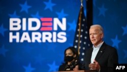 Democratic presidential candidate Joe Biden speaks as US Senator and vice presidential candidate, Kamala Harris, looks on at the Queen venue in Wilmington, Delaware, on Nov. 5, 2020.