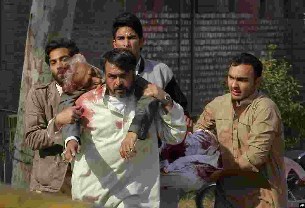 People rush an injured person to the hospital following a suicide attack at a Shi'ite mosque in Peshawar, Feb. 13, 2015.
