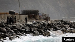 Miembros de la unidad de fuerzas especiales observan un bote vacío en la orilla, luego de que el gobierno de Venezuela anunciara una incursión "mercenaria" fallida, en Macuto, Venezuela, el 3 de mayo de 2020. 