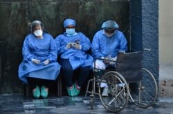 Health workers wear face masks and face shields against the spread of the new coronavirus at the Honduran Institute of Security in Tegucigalpa on March 31, 2020.