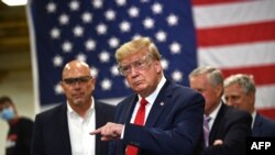 រូបឯកសារ៖ ប្រធានាធិបតីអាមេរិកលោក ដូណាល់ ត្រាំ ចូលពិនិត្យមើលរោងចក្រផលិតគ្រឿងប្រដាប់ការពារផ្នែកសុខាភិបាលមួយនៅក្រុង Phoenix រដ្ឋ Arizona កាលពីថ្ងៃទី០៥ ខែឧសភា ឆ្នាំ២០២០។ 