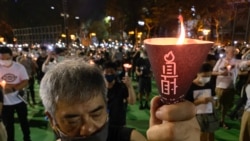 參與六四31周年維園燭光集會的市民高舉燭光，為六四屠城死難者默哀一分鐘 （攝影：美國之音湯惠芸）