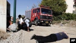 Israelis take cover as a siren warning of an incoming rocket sounds in Kiryat Malachi, southern Israel, Thursday, November 15, 2012.
